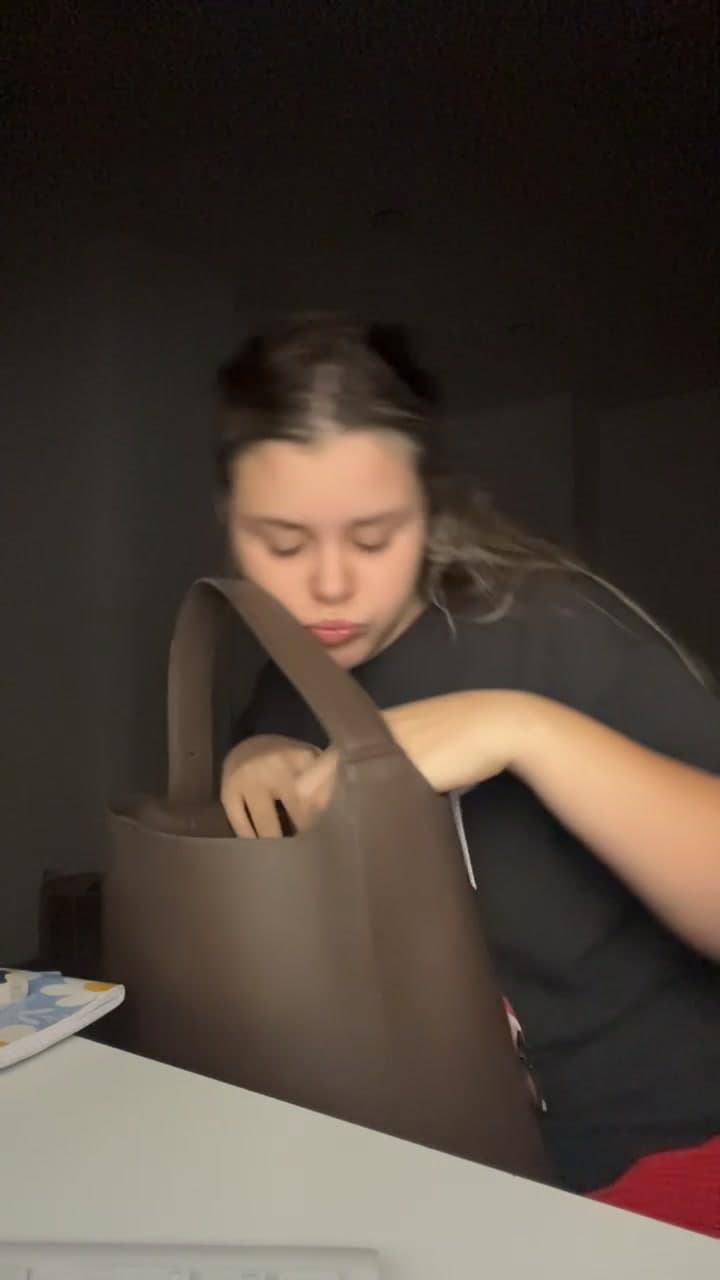 Young Woman Organizing Bag at Desk