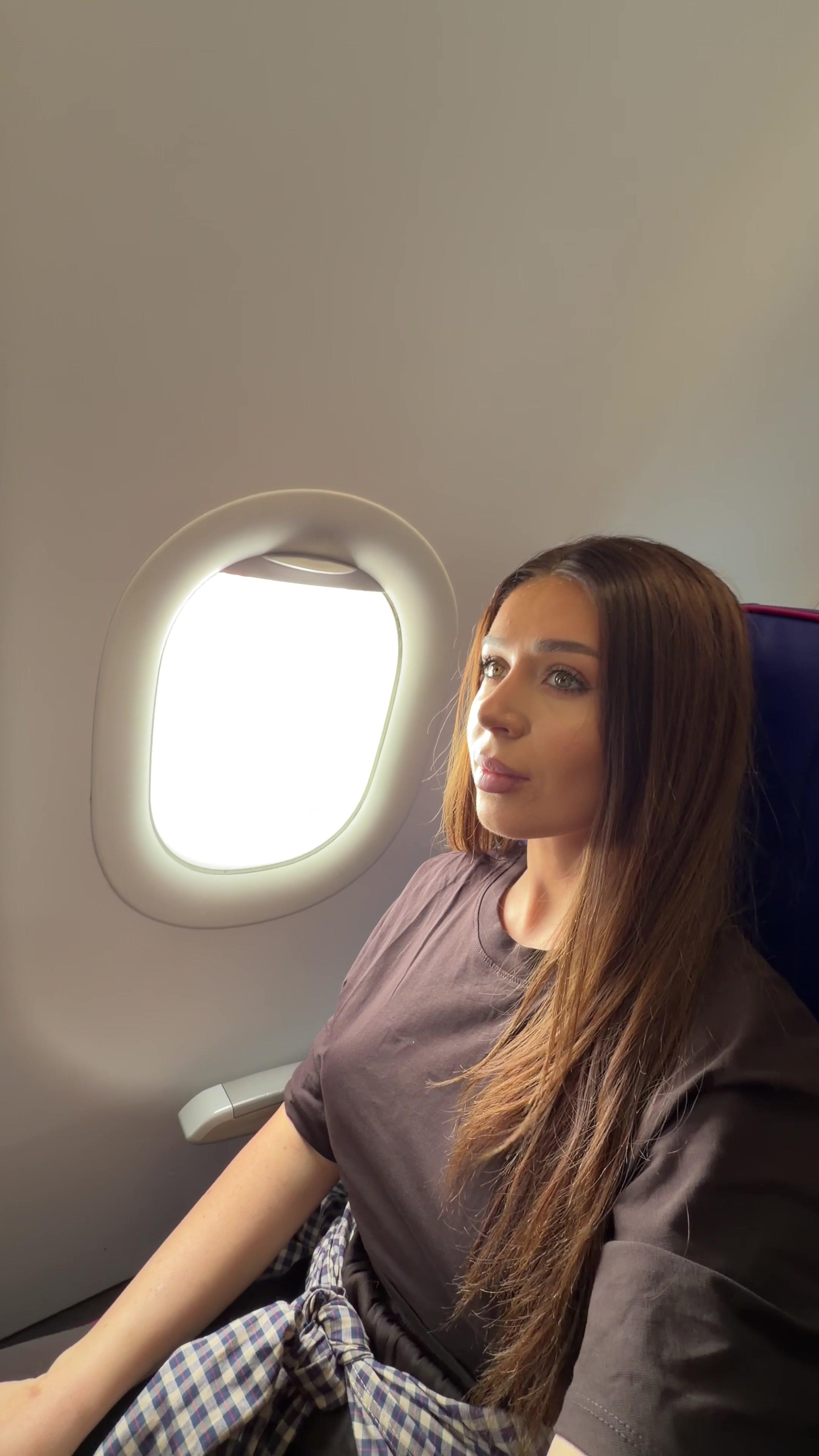 Woman Looking Out Airplane Window